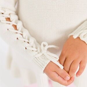 RuffleButts - Girls Ivory Ruffle Hem Lace Up Sweater